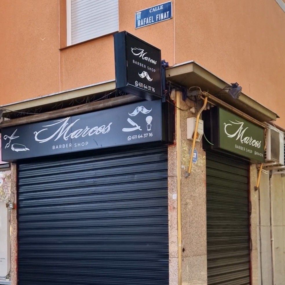 Fachada de Marcos Barber Shop en la esquina de la calle Rafael Finat, con el rótulo negro y el cartel luminoso