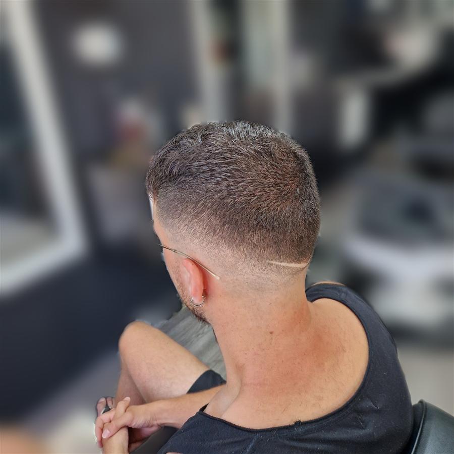 Taper fade con línea perfilada junto a la oreja